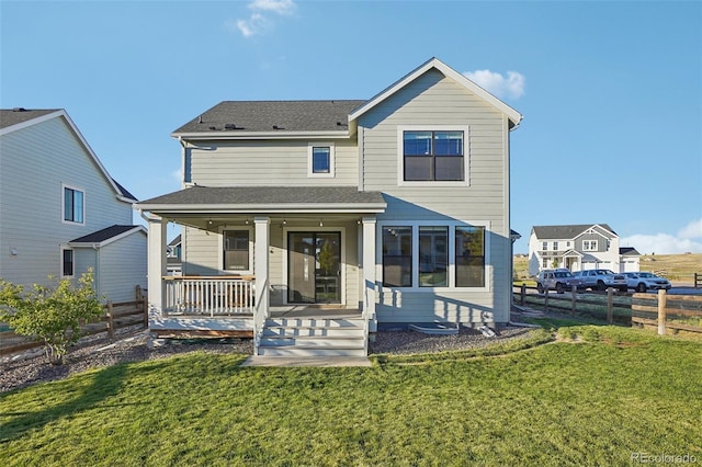 back of property featuring covered porch and a yard