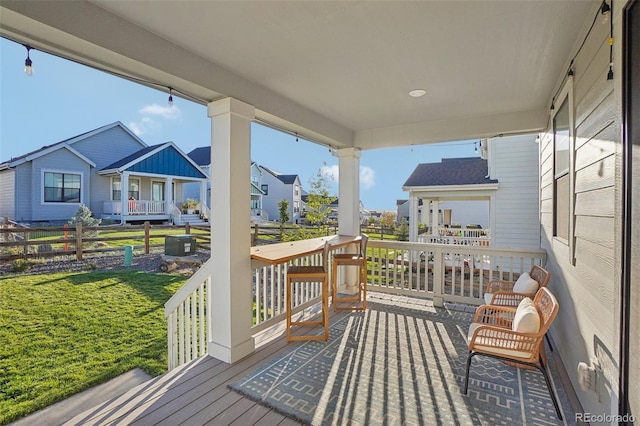 wooden deck featuring a lawn and a porch