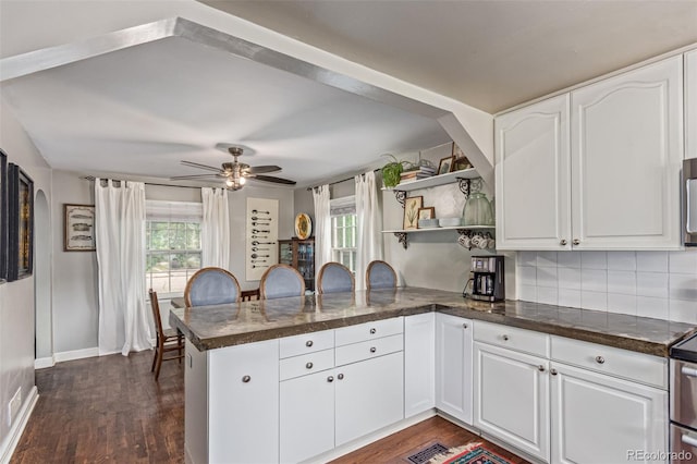 134 S 5th Ave, Brighton, CO 80601 - kitchen featuring a peninsula, dark wood-type flooring, white cabinetry, ceiling fan, and open shelves