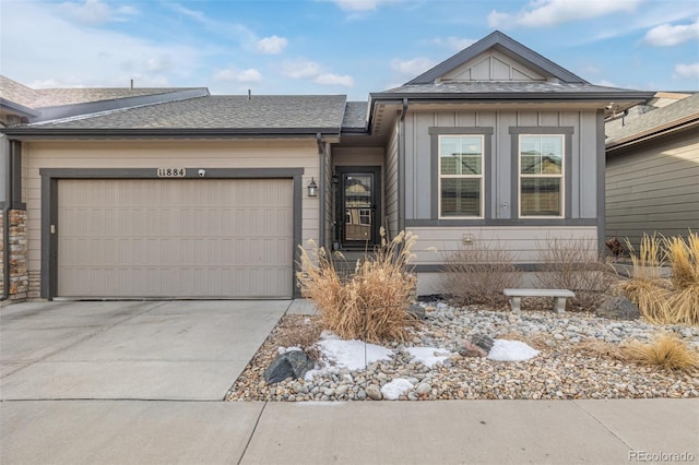 view of front of home featuring concrete driveway, board and batten siding, an attached garage, and roof with shingles