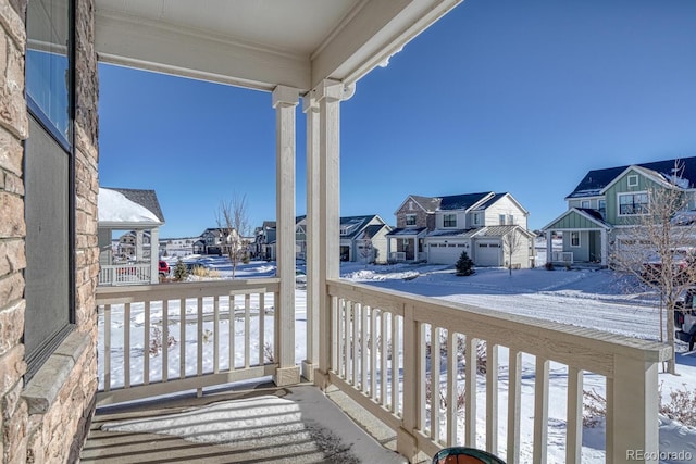 snow covered back of property with a porch