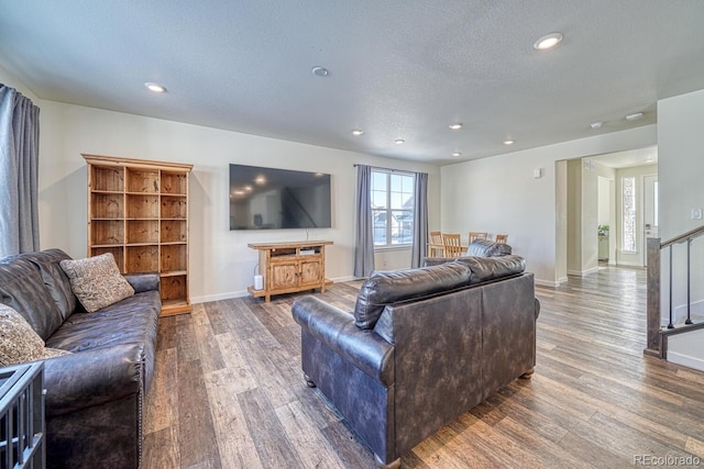 living room with a textured ceiling and dark hardwood / wood-style flooring