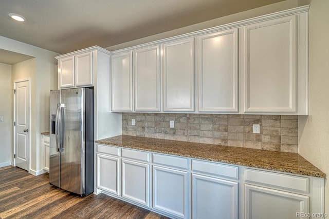 kitchen featuring dark stone counters, white cabinets, dark hardwood / wood-style floors, tasteful backsplash, and stainless steel fridge with ice dispenser