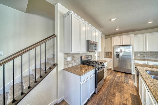 kitchen featuring decorative backsplash, white cabinets, and stainless steel appliances