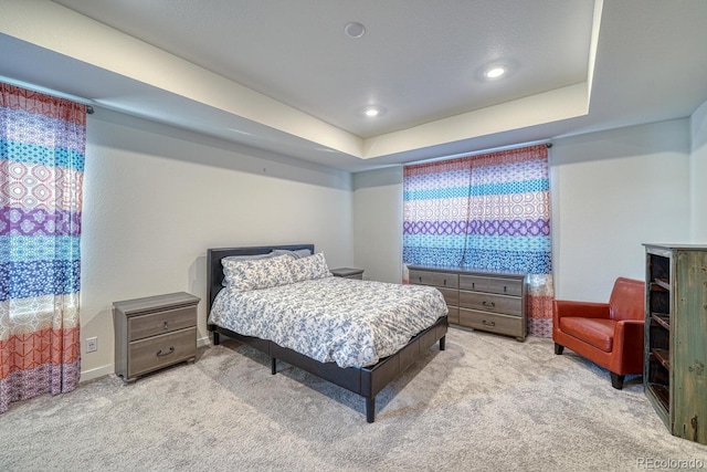 carpeted bedroom featuring a tray ceiling