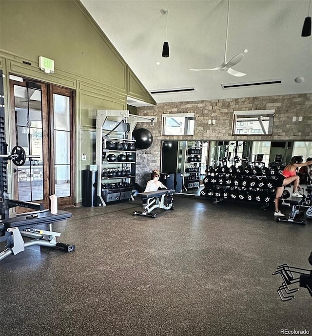 exercise room featuring ceiling fan and high vaulted ceiling