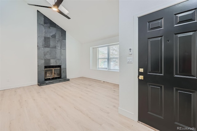 entrance foyer featuring ceiling fan, a fireplace, vaulted ceiling, and light hardwood / wood-style flooring