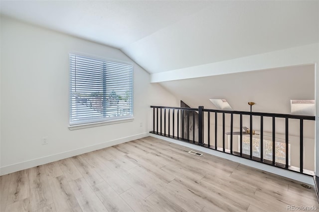 additional living space featuring lofted ceiling and light hardwood / wood-style flooring