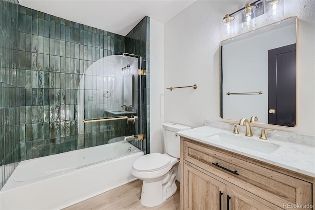 full bathroom with vanity, tiled shower / bath combo, wood-type flooring, and toilet