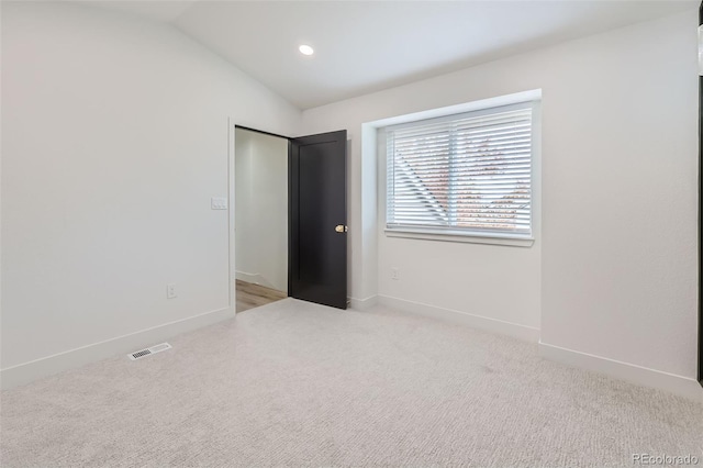 unfurnished bedroom with lofted ceiling and light carpet