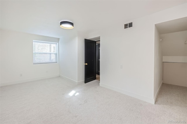 spare room featuring light colored carpet