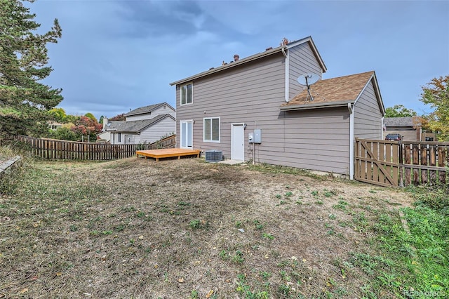 rear view of property with cooling unit and a deck