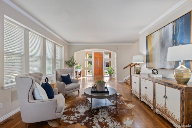 6874 Raspberry Run, Littleton, CO 80125 - living room featuring arched walkways, baseboards, ornamental molding, wood finished floors, and stairs