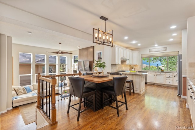 6874 Raspberry Run, Littleton, CO 80125 - dining space featuring light wood-style flooring, recessed lighting, a chandelier, baseboards, and a ceiling fan