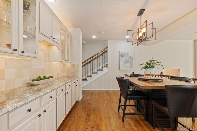 6874 Raspberry Run, Littleton, CO 80125 - dining room with dark wood-type flooring, recessed lighting, stairway, baseboards, and a chandelier
