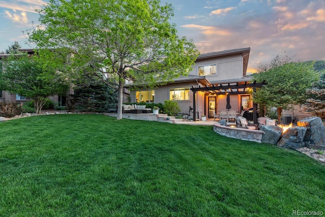 6874 Raspberry Run, Littleton, CO 80125 - back of property at dusk featuring a pergola, an outdoor living space with a fire pit, a patio, and a yard