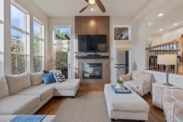 6874 Raspberry Run, Littleton, CO 80125 - living area with a tiled fireplace, dark wood finished floors, a ceiling fan, and recessed lighting