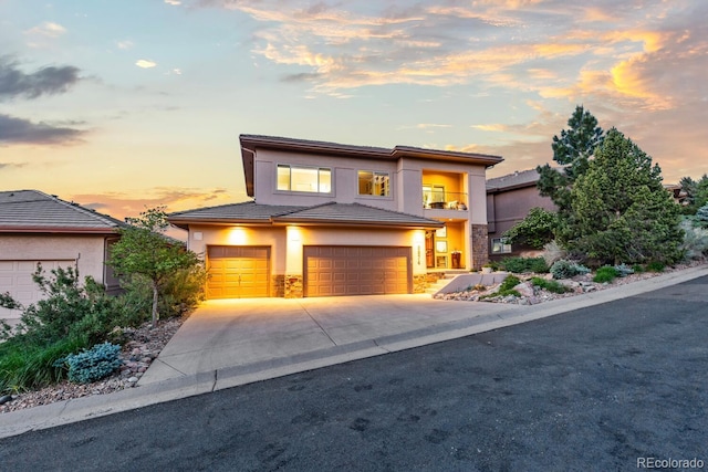 6874 Raspberry Run, Littleton, CO 80125 - view of front of property featuring an attached garage, a tiled roof, stucco siding, concrete driveway, and a balcony