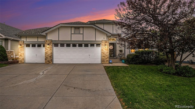 view of front of property with a garage, stucco siding, driveway, and a front yard