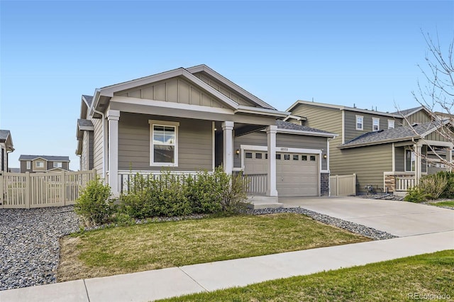 10555 Boston St, Commerce City, CO 80640 - view of front of home with an attached garage, concrete driveway, covered porch, and board and batten siding