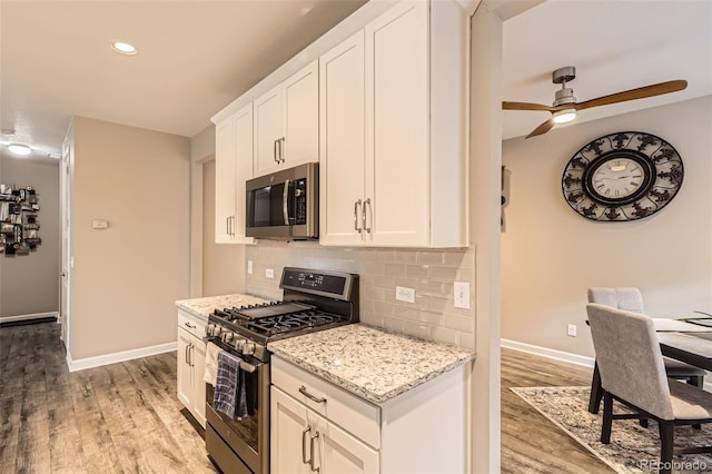 10555 Boston St, Commerce City, CO 80640 - kitchen with appliances with stainless steel finishes, baseboards, light wood finished floors, tasteful backsplash, and recessed lighting
