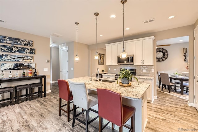 10555 Boston St, Commerce City, CO 80640 - kitchen featuring stainless steel appliances, a sink, light wood finished floors, tasteful backsplash, and recessed lighting