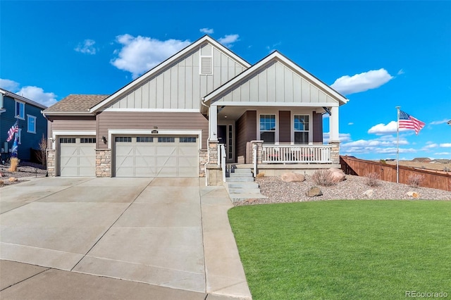 craftsman inspired home with covered porch, board and batten siding, a front yard, a garage, and driveway