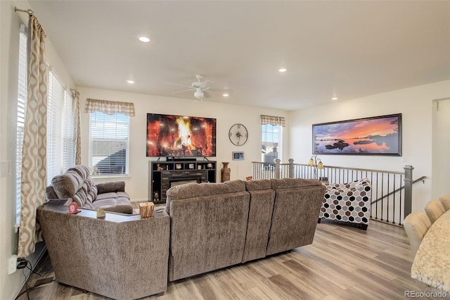 living room featuring recessed lighting, a fireplace, and light wood-style flooring