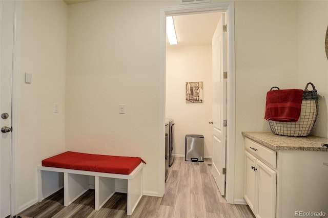 mudroom featuring light wood-style floors, independent washer and dryer, and baseboards