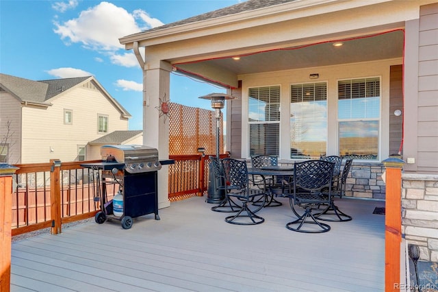 wooden terrace featuring outdoor dining space and area for grilling