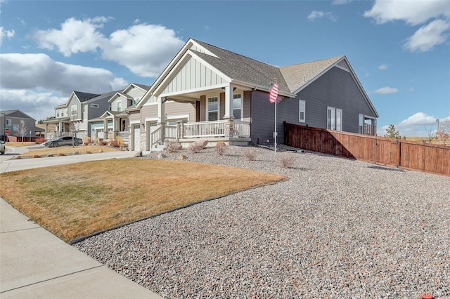 craftsman-style house with concrete driveway, a residential view, fence, a porch, and board and batten siding