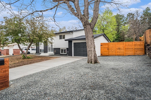 11172 W Exposition Dr, Denver, CO 80226 - view of front of house with concrete driveway, an attached garage, and fence