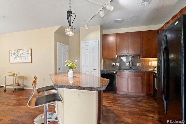 2662 S Cathay Way Unit 112, Aurora, CO 80013 - kitchen with black appliances, dark wood finished floors, a sink, a center island, and tasteful backsplash