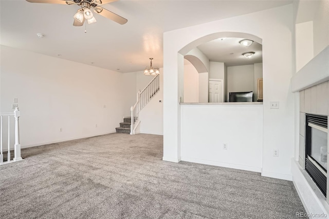 12711 Colorado Blvd Unit 607F, Thornton, CO 80241 - unfurnished living room with carpet floors, ceiling fan, a glass covered fireplace, stairway, and arched walkways