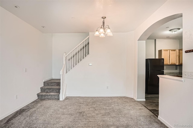 12711 Colorado Blvd Unit 607F, Thornton, CO 80241 - unfurnished living room with arched walkways, carpet floors, a chandelier, and stairs