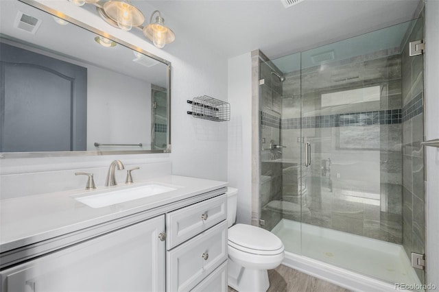 35055 E Mississippi Ave, Watkins, CO 80137 - bathroom with a stall shower, toilet, visible vents, vanity, and wood finished floors