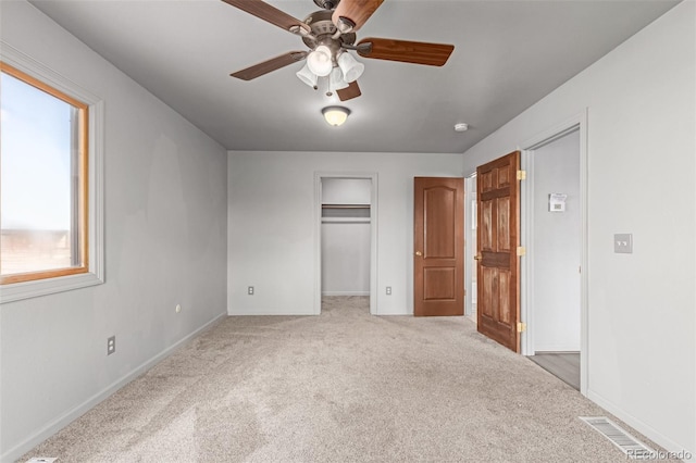 35055 E Mississippi Ave, Watkins, CO 80137 - unfurnished bedroom with baseboards, ceiling fan, visible vents, a walk in closet, and light carpet