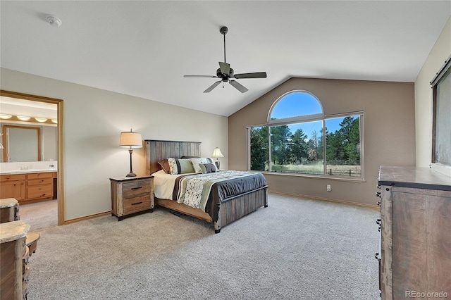 carpeted bedroom with ceiling fan, ensuite bathroom, and vaulted ceiling