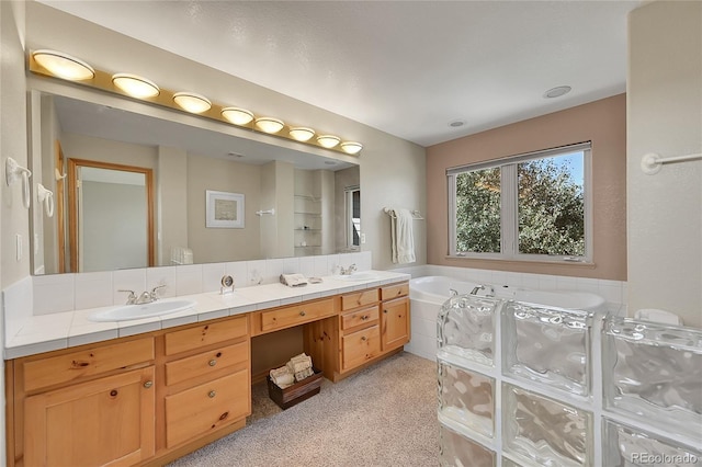 bathroom with tiled bath and vanity