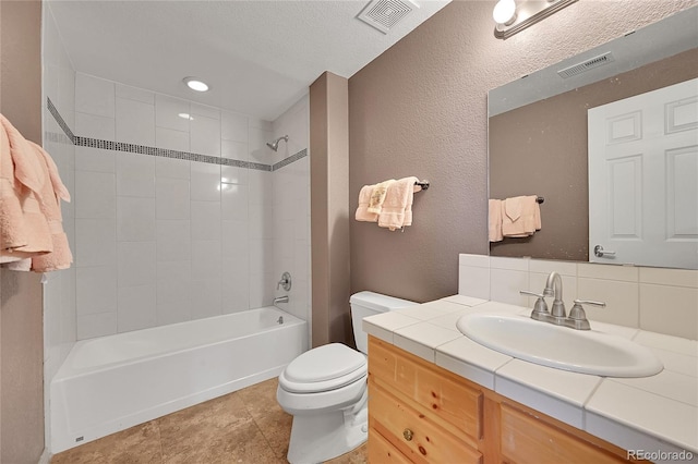 full bathroom with toilet, vanity, a textured ceiling, tasteful backsplash, and tiled shower / bath combo