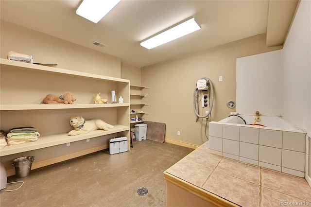 interior space featuring a bathing tub and concrete flooring