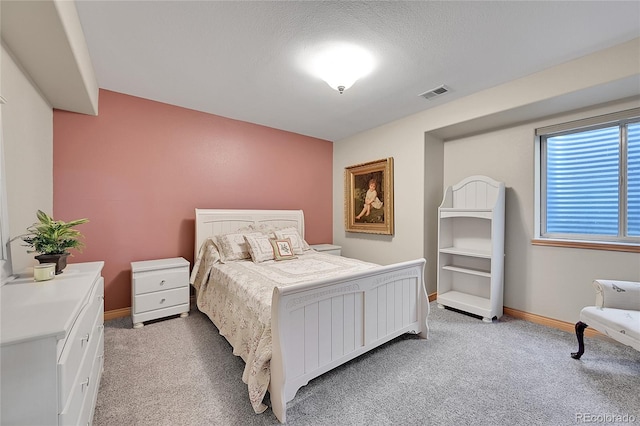 carpeted bedroom featuring a textured ceiling