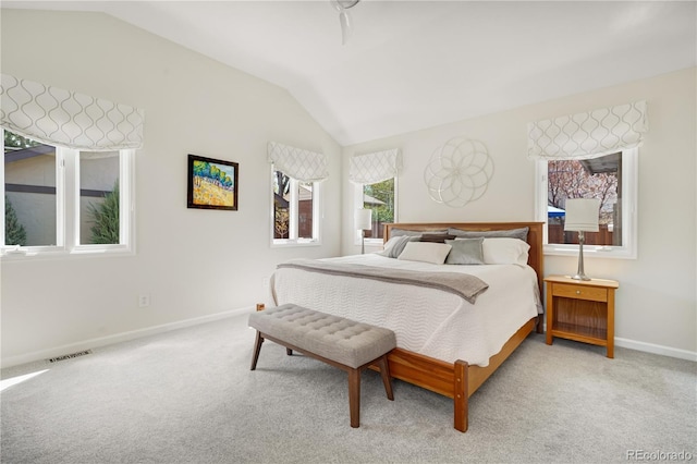 bedroom featuring vaulted ceiling, light colored carpet, and baseboards