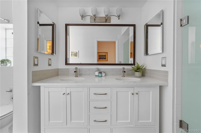 bathroom featuring toilet, double vanity, and a shower