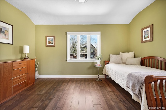 bedroom with dark wood-type flooring, baseboards, and lofted ceiling