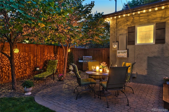 view of patio / terrace featuring fence, outdoor dining area, and a grill