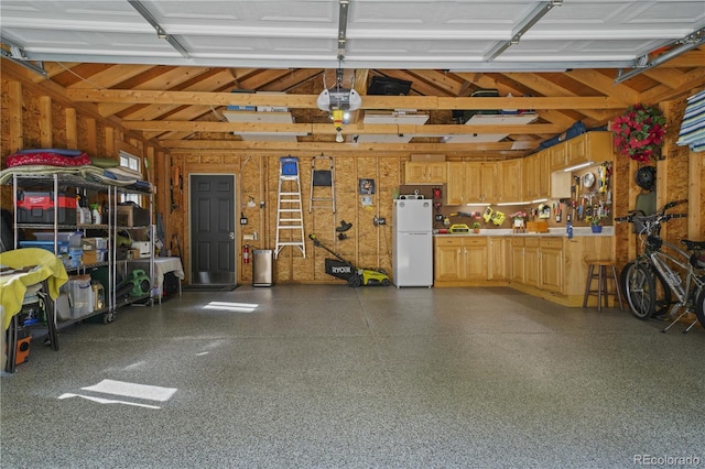 garage with freestanding refrigerator and a garage door opener
