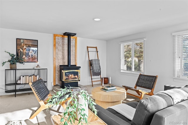 carpeted living room featuring a wood stove