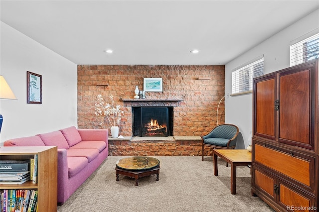 carpeted living room featuring a brick fireplace and a wealth of natural light