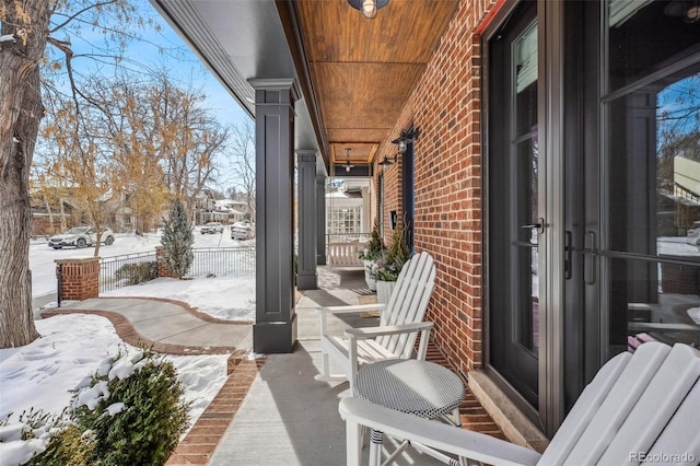 snow covered patio featuring a porch